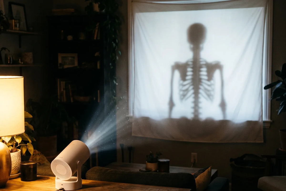 Le projecteur sur un meuble, la toile tendue dans la fenêtre, une silhouette projetée